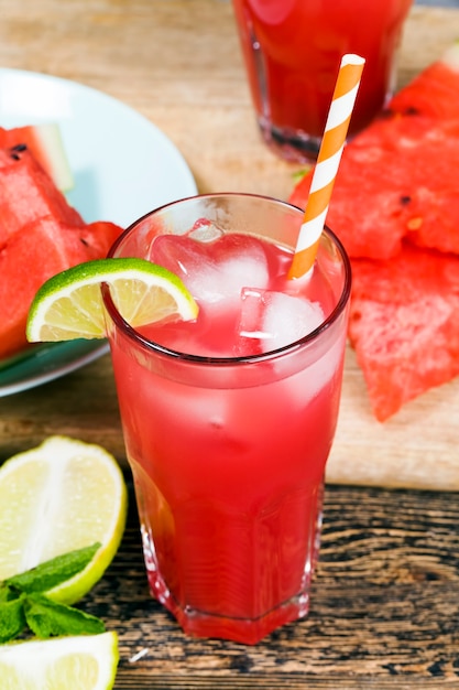 Watermelon juice from ripe red and juicy watermelons, red juice is a natural healthy and dietary product, watermelon juice is poured into a glass container