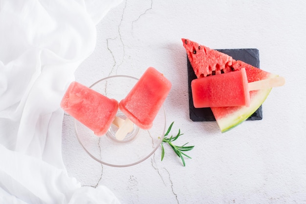 Watermelon popsicles in a bowl and a piece of watermelon on the table Homemade dessert Top view