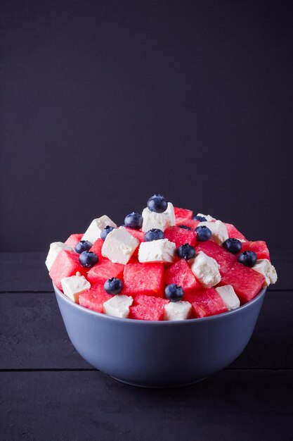 Watermelon salad with feta cheese in gray bowl Healthy salad with blueberries watermelon