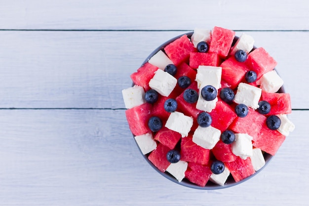 Watermelon salad with feta cheese in gray bowl Healthy salad with blueberries watermelon