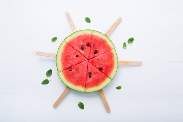 Watermelon slice popsicles on white background