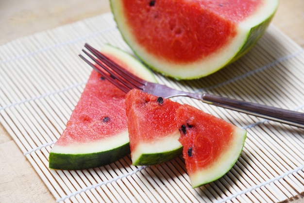 Watermelon slice on wooden board with fork