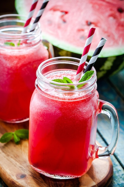 Watermelon smoothie in a mason jar on a wooden board