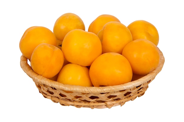 Wattled basket with ripe yellow apricots isolated on white background