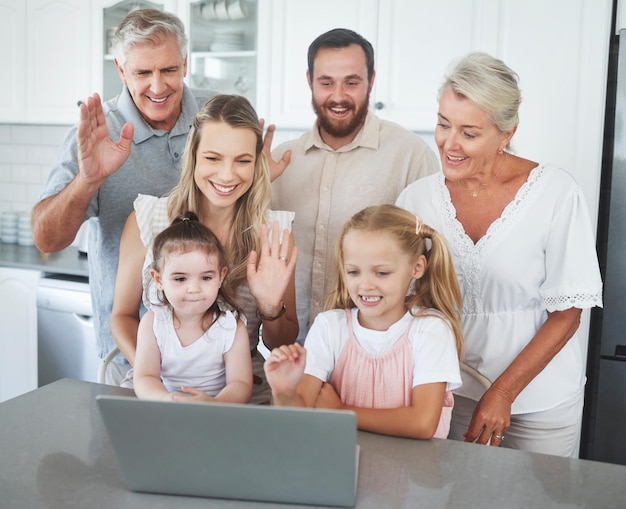 Wave children and happy family on laptop video call for communication conversation or relax in home kitchen Mom dad and grandparents or big family hello on video conference chat or online contact