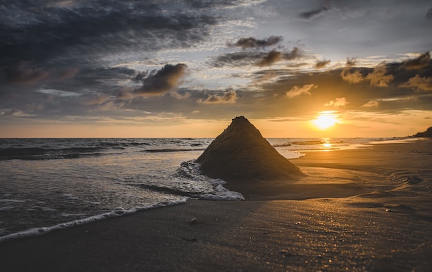 Wave crashing on a sand pyramid