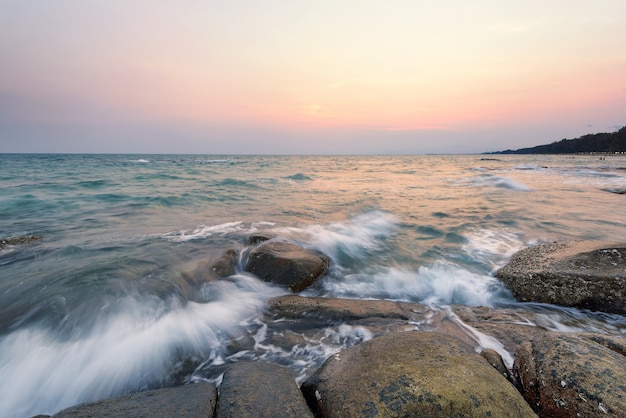 wave hit the rock at sunset