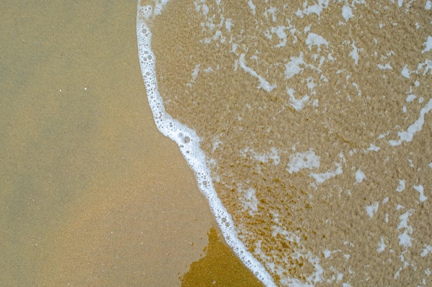 Wave of salty sea water on the beach sand