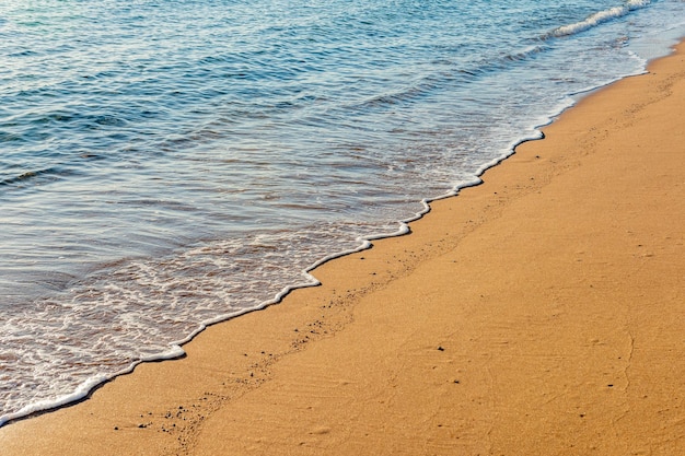 Wave of the sea with foam on the sand beach