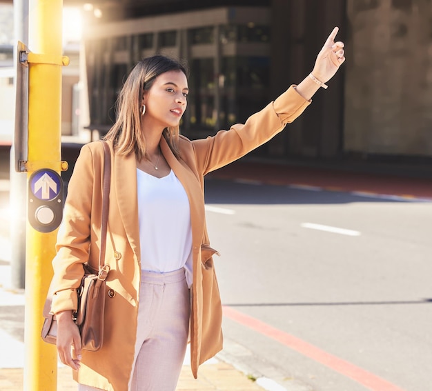 Wave taxi and woman in city for cab transportation and commute travel in cbd for business or meeting Person hand and sign to call attention of taxicab driver and passenger service in town