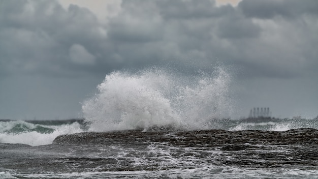 Waves breaking coastal rocks, selective focus