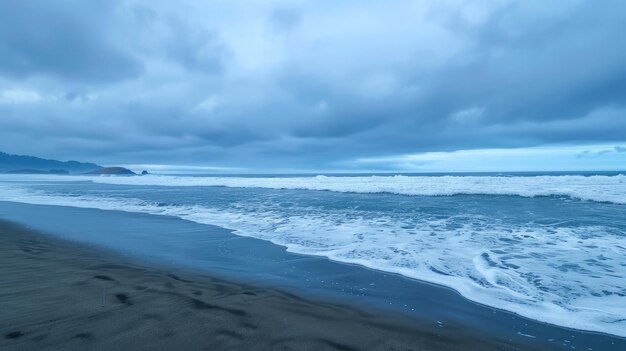 Waves crash on a sandy beach creating white foam as the sun rises Dark storm clouds fill the sky above