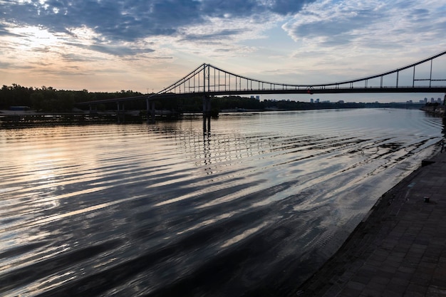 Waves and sky reflection under the bridge on Dnipro river Kyiv city Ukraine