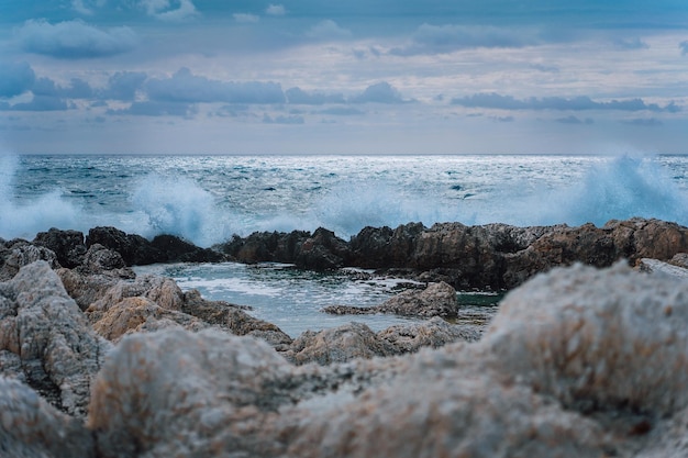 Waves splashing against rocky coastline and building natural pools Dramatic cloudscape