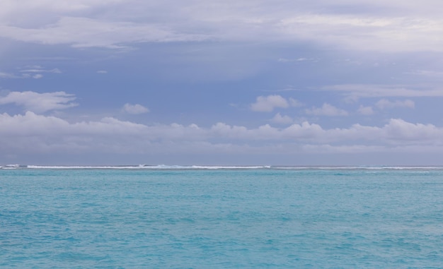 waves on turquoise water in the ocean and sky with clouds