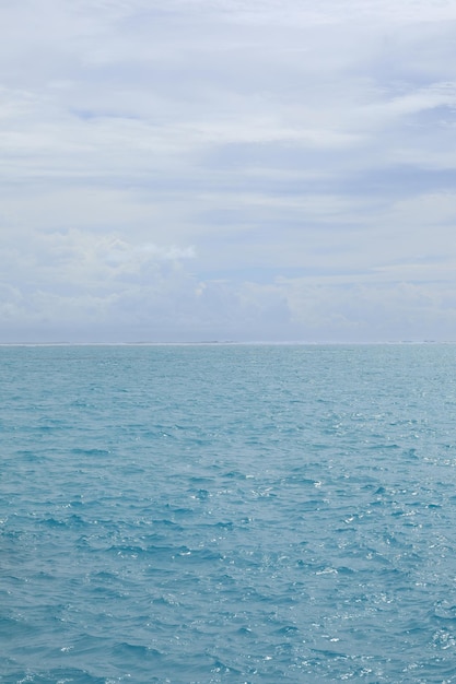 waves on turquoise water in the ocean and sky with clouds