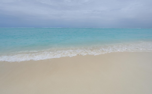 waves on turquoise water in the ocean and sky with clouds