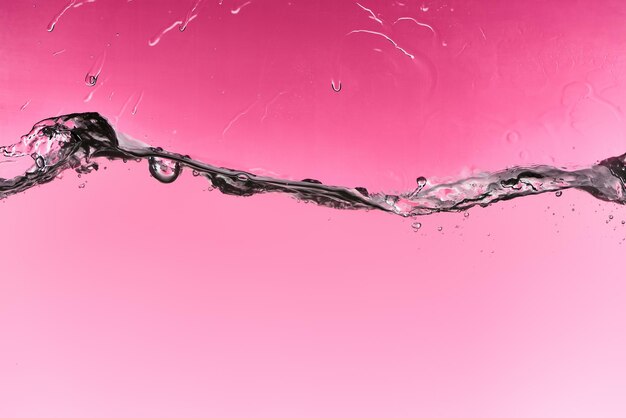 Wavy fresh water on pink background with drops and bubbles