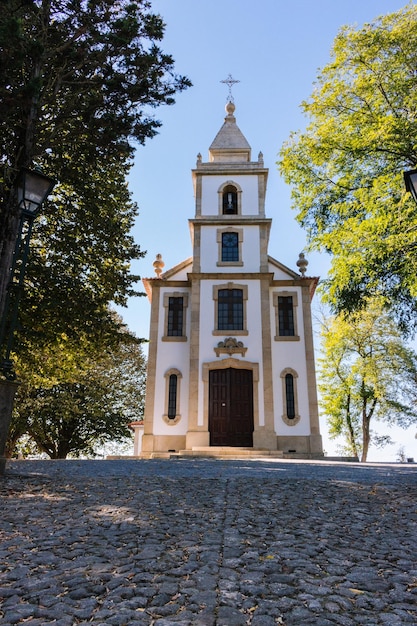 Way to the church. Catholic church exterior. Beautiful church in summer park. Religious architecture