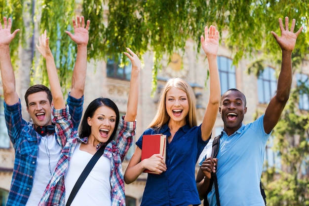 We are happy! Four happy young people making selfie while standing close to each other outdoors