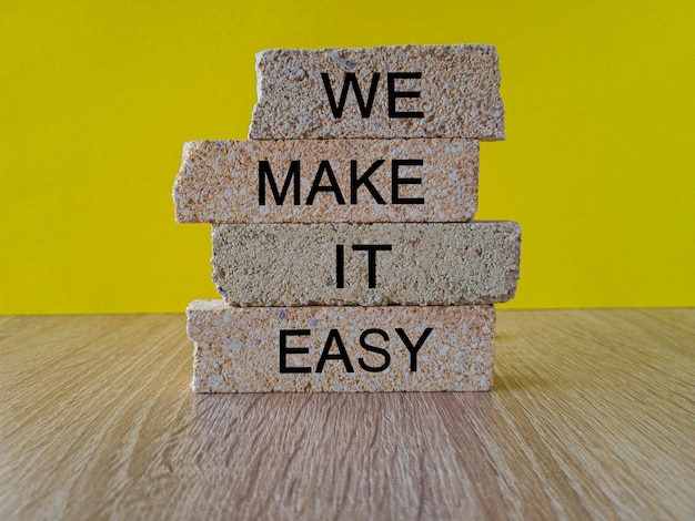 We make it easy symbol Concept words We make it easy on brick blocks Beautiful wooden table