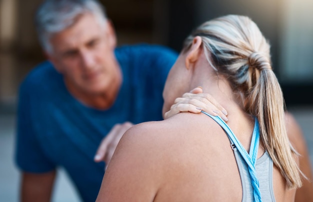 Photo we need get that checked out asap honey shot of a mature woman holding her neck in pain after an intense workout session with her husband