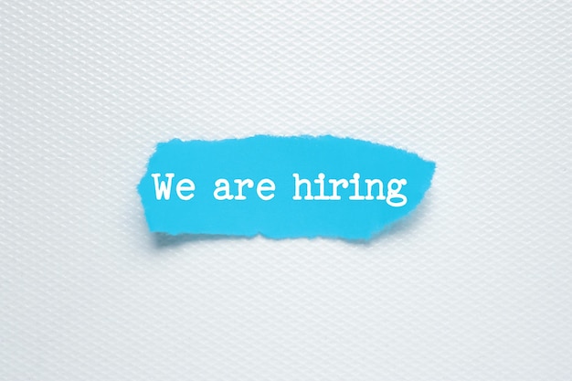 We're Hiring written under torn paper Human resource concept strategy plan planning