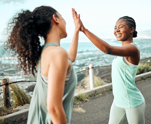 We reached another fitness goal Shot of two young women giving each other a high five while working out in nature