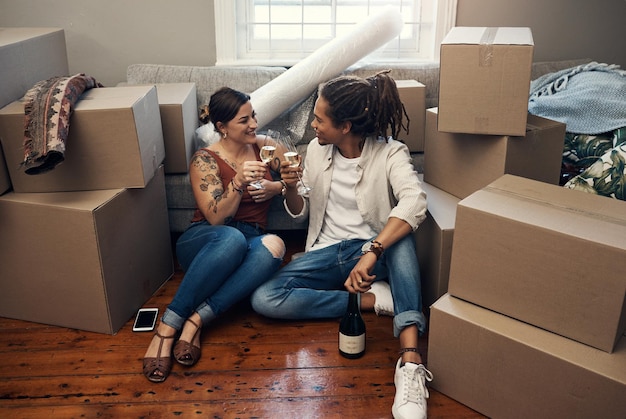 We really deserve it babe Shot of a happy young couple having champagne to celebrate their new home