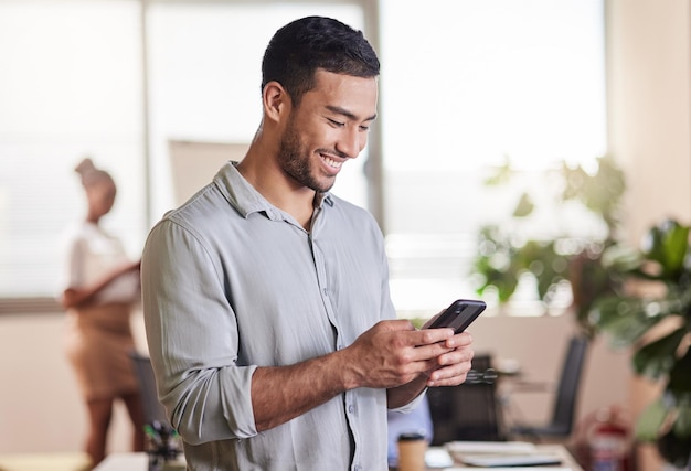 We should get together Shot of a young businessman using his smartphone to send a text message