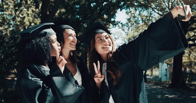 Photo we want to commemorate one of the most special days of our entire lives shot of a group of female students taking a selfie on graduation day