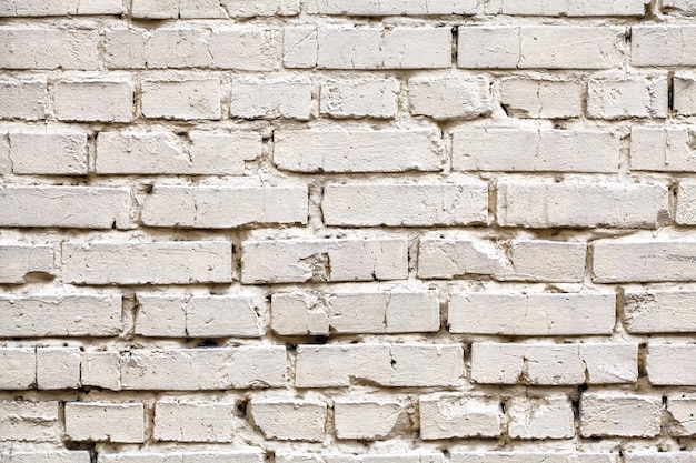 Weathered stained white brick wall