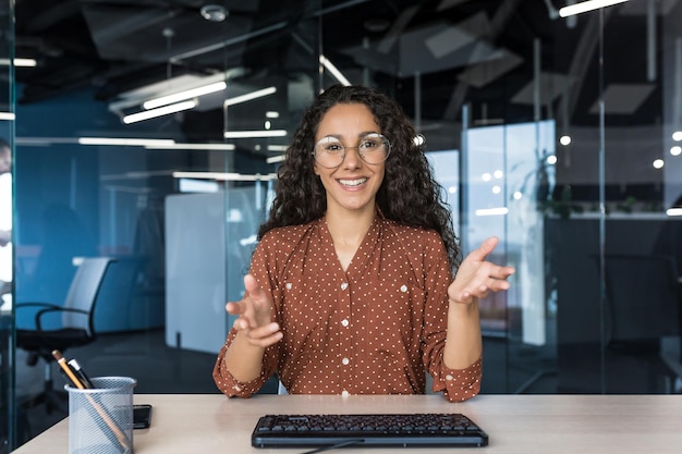 Webcam view happy hispanic businesswoman smiling and looking at camera video call with colleagues