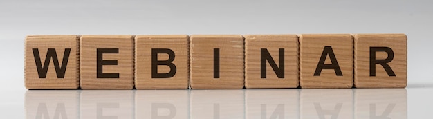 Webinar word on wooden cubes on white glossy background with reflection