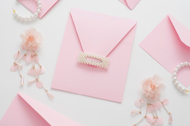 Wedding background, decorated with pink invitations and pearl jewelry