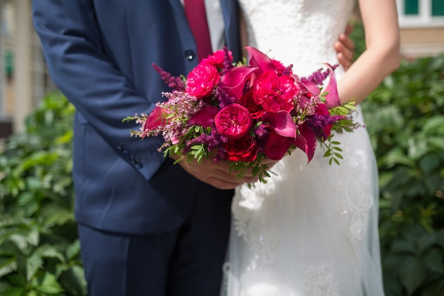 Wedding Beautiful Wedding bouquet of different flowers in the hands of the bride