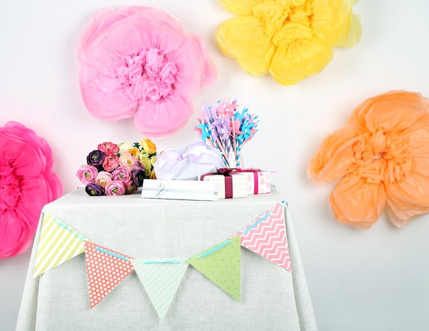 Photo wedding or birthday gifts on decorated table, on bright background