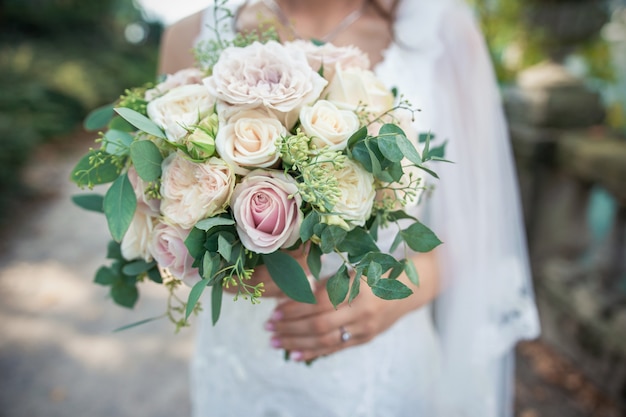 Wedding bouquet in bride's hands. Luxurious bouquet in the hands of the bride in a wedding dress.