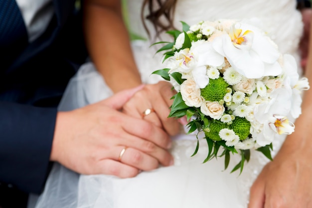 Wedding bouquet and hands with rings