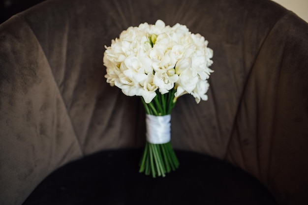 Wedding bouquet of peonies lying on the chair