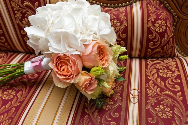 A wedding bouquet of roses lies on the baroque couch. Bouquet of roses, wedding flowers.