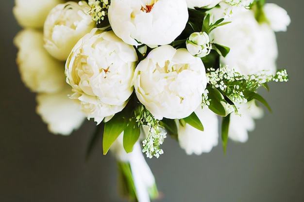 Wedding bouquets white peony flowers on blurry grey background