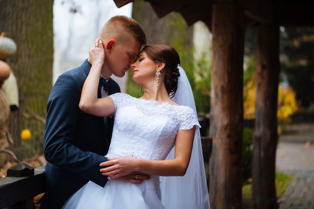 Wedding bride and groom kissing loving couple with roses bouquet flowers at winter bridal day Enjoy moment of happiness and having fun. playful newlywed family woman and man in love. gorgeous bride