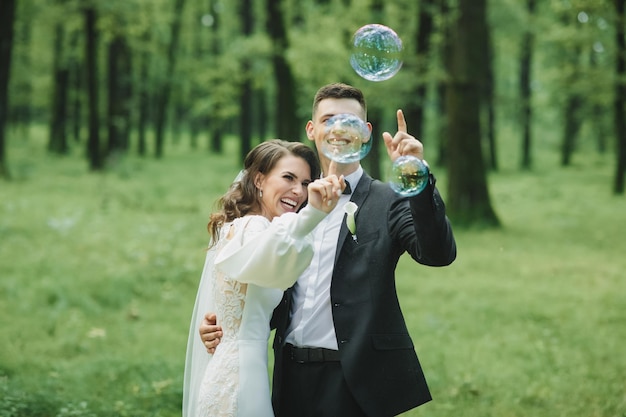 Wedding. Bride and groom soap bubbles burst