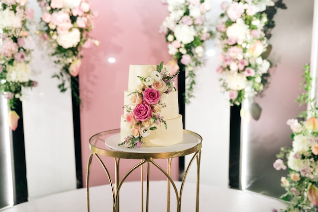 Wedding cake on table with floral background