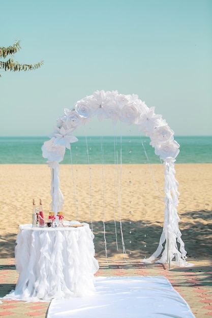 Wedding ceremony arch with white flowers on sea background