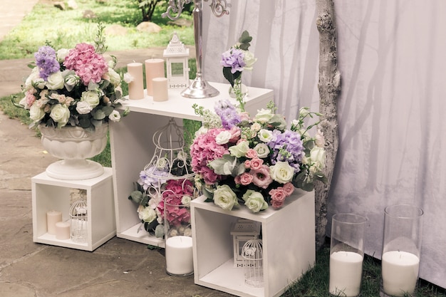 Wedding ceremony decorations bouquets of flowers/ candles in restaurant outdoors.