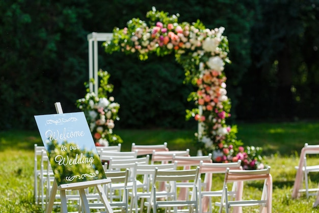 Wedding ceremony decorations chairs mirror pointer and a lot of flowers in white and pink colors