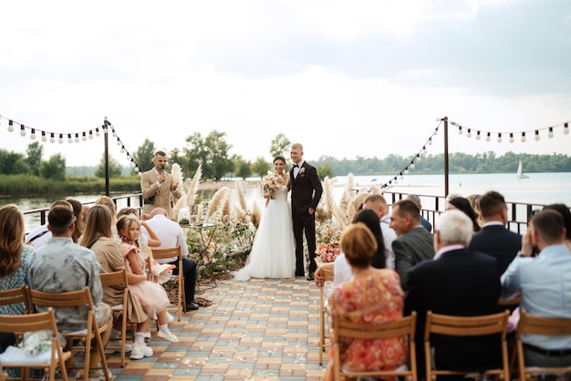 Wedding ceremony on a high pier near the river