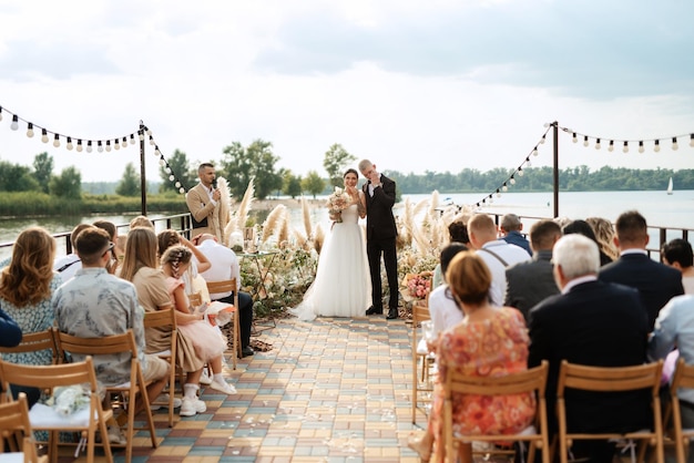 Wedding ceremony on a high pier near the river